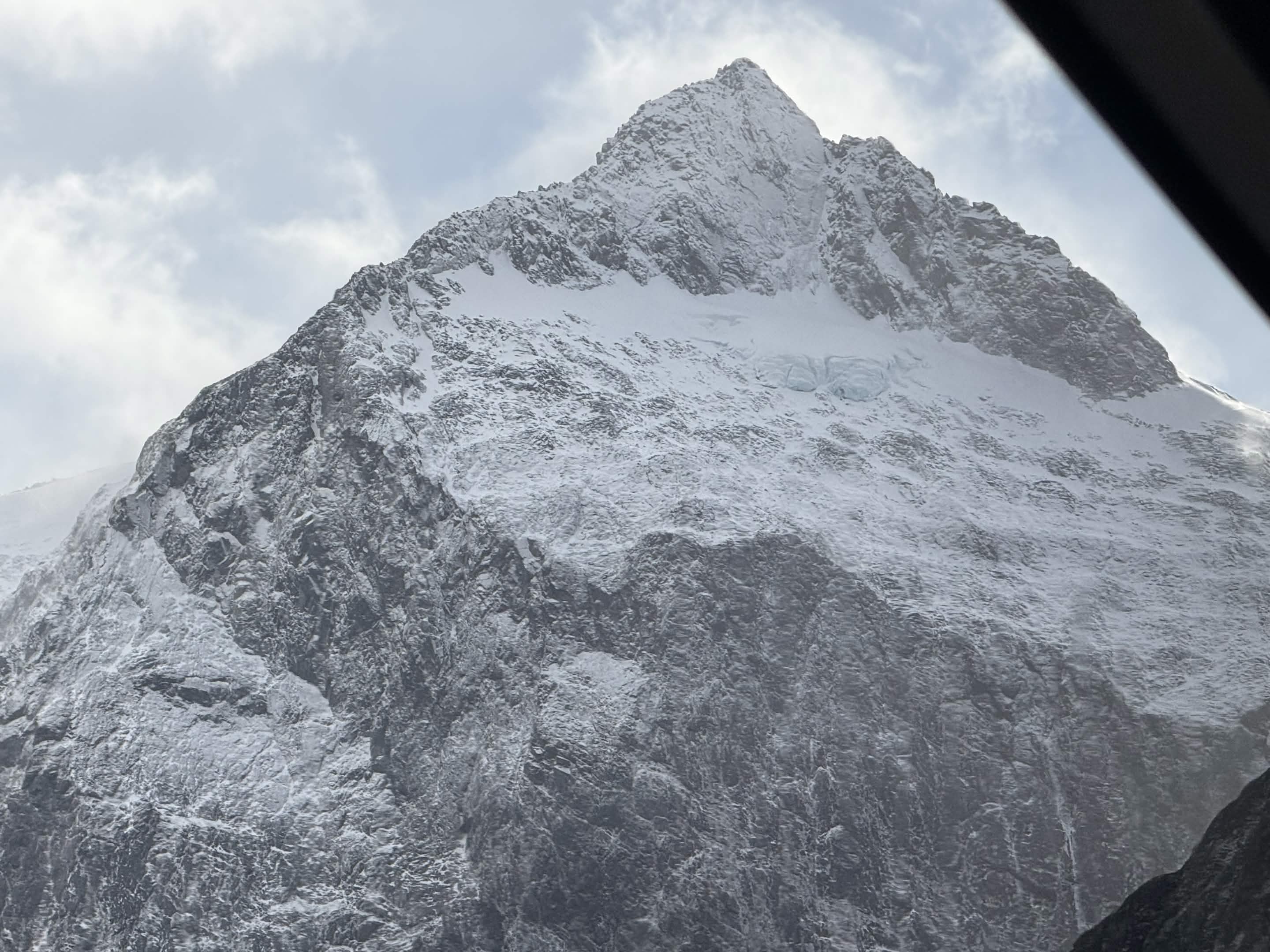 A jagged snow-and-ice peak towering over the Milford road, seen looking up from the coach